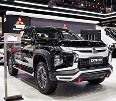 a black truck is on display at an auto show