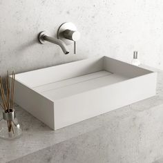 a white sink sitting on top of a counter next to a toothbrush holder