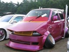 a purple car parked in a parking lot next to other cars