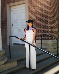 a woman in a graduation gown standing on the steps