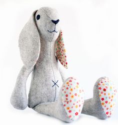 a gray stuffed animal sitting on top of a white table