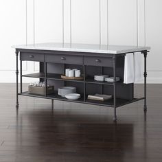 a kitchen island with marble top and metal legs, in front of a white wall