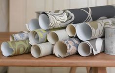 several rolls of wallpaper sitting on top of a wooden table next to each other