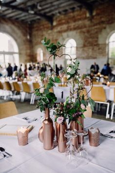 there are many vases with flowers in them on the table at this wedding reception