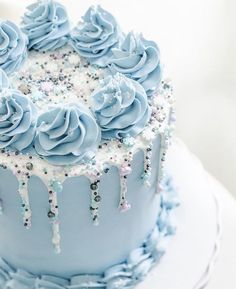 a blue frosted cake with icing and sprinkles on the top