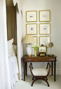 an image of a bedroom with pictures on the wall and a desk in front of it