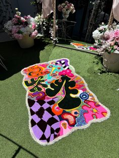 a colorful rug on the ground in front of flowers