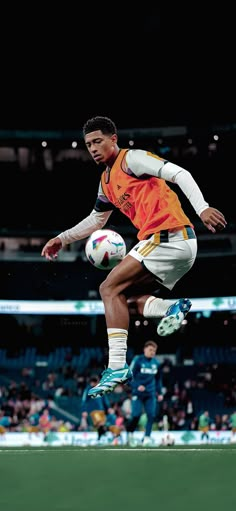 a man kicking a soccer ball on top of a field