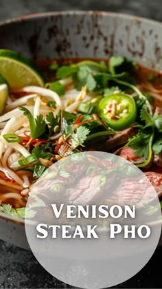 a bowl filled with meat and veggies next to a lemon wedge on top of a table