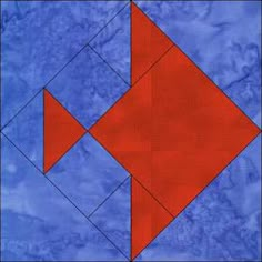 a blue and red quilt with an orange fish in the center on top of it