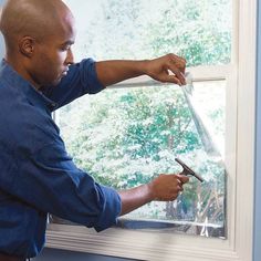 a man in blue shirt using window sealer