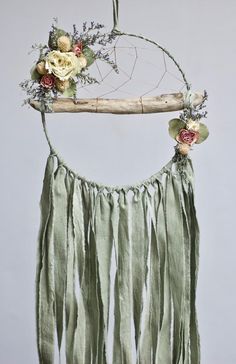 a dream catcher with flowers and branches hanging from it