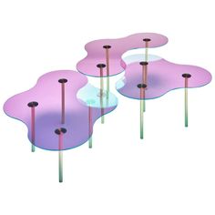 four pink and purple flower shaped glass tables with metal poles on each side, set against a white background