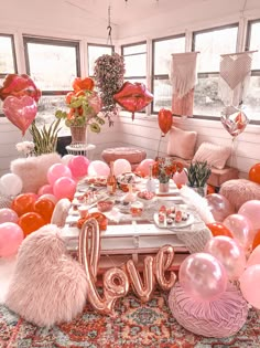 a room filled with balloons and other decorations in the shape of love on top of a rug