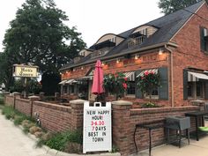 the outside of a restaurant with tables and umbrellas on it's patio area