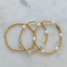 This bracelet stack is perfect for ocean lovers, featuring dainty beaded bracelets in plain gold, rice pearls, and turquoise glass beads. This holiday gift set is an ideal present for anyone who loves the sea and the calming blues of the ocean. Bring the beach wherever you go with this beautiful bracelet stack! Please refer to the size chart for your bracelet size. Beachy Gifts, Trendy Beaded Bracelets, Coastal Bracelet, Beaded Bracelet Stack, Dainty Chain Necklace, Rice Pearls, Bracelet Inspo, Holiday Gift Sets, Turquoise Glass