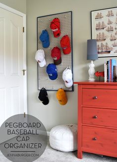 several hats are hanging on a pegboard in the corner of a room next to a dresser