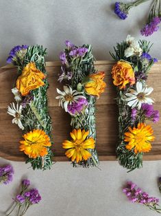 flowers laid out on a wooden board with purple and yellow flowers in the middle next to them