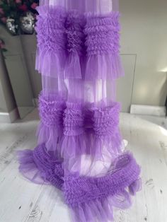 the purple ruffled skirt is hanging on the wall