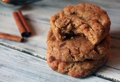 three cookies stacked on top of each other with cinnamon sticks in the background and an empty glass bowl next to them