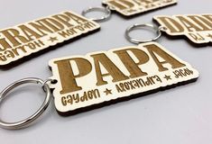 four wooden key chains with the words papa and grandpa printed on them, sitting next to each other