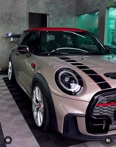 a silver and black car is parked in a room with checkered tile flooring