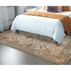 a bed sitting on top of a wooden floor next to a white dresser and window