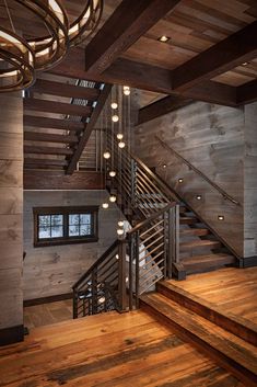 a wooden staircase with lights hanging from it's sides and wood flooring on the other side