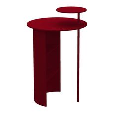 a red table sitting on top of a white floor next to a tall metal pole