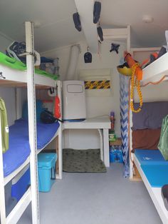 there are many bunk beds in this small room with blue and green mats on the floor