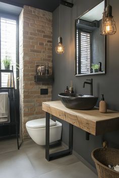 a bathroom with a sink, toilet and brick wall in the back drop off area