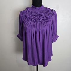 This Ann Taylor Blouse Features A High Neck And Ruffled Puff Sleeves, With A Pleated And Buttoned Keyhole Accent. The Garment Is Made From Polyester And Has A Regular Fit, Making It Suitable For A Variety Of Occasions Including Parties, Casual Wear, Workwear, And Business Settings. The Blouse Is Available In A Size Medium And Is Machine Washable For Easy Care. The Solid Purple Color And Bohemian Theme Make It A Great Addition To Any Wardrobe, While The Peasant And Bohemian Themes Add A Touch Of Solid Purple Color, Bohemian Theme, Neck Ruffle, Office Casual, Puff Sleeves, Purple Color, Ann Taylor, Puff Sleeve, Work Wear