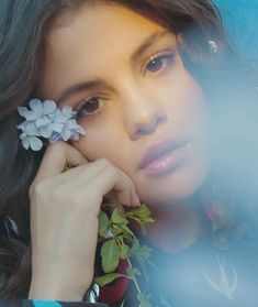 a close up of a person holding a flower