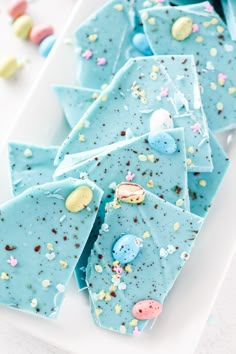 blue candy barkies with buttons and sprinkles on a white platter