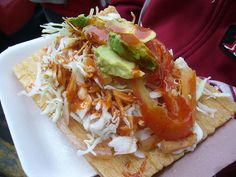 a white plate topped with nachos covered in toppings