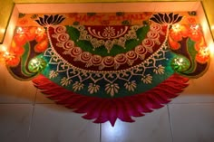 an elaborately decorated wall hanging on the side of a building with candles in it