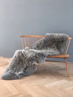 two sheepskin rugs sitting on a wooden chair