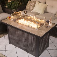 a fire pit sitting on top of a patio table next to a couch and coffee table