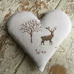 a heart shaped ornament with a deer and tree on it