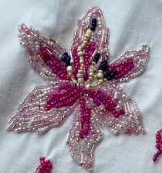 the beaded flower is pink and white