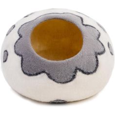 a gray and white flower shaped object on a white surface with an orange spot in the center