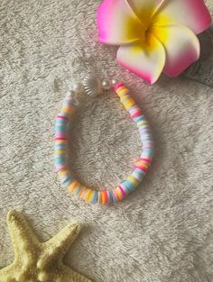 a starfish bracelet and a flower on a towel