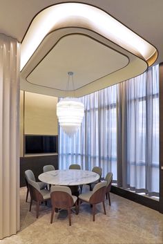 a dining room table with chairs and a chandelier hanging from it's ceiling