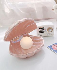 an egg shell shaped object sitting on top of a table next to a toaster