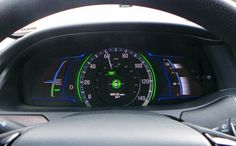 the dashboard of a car with green and blue lights on it's dash board