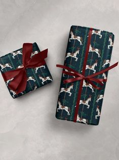 two wrapped presents with red ribbon on them, one in the shape of a horse