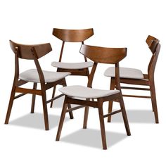 four wooden chairs with white upholstered seats and backrests, all facing different directions