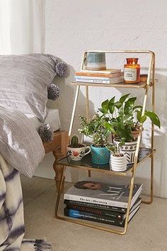 a bedroom with a bed, nightstand and plants