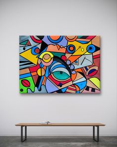 an abstract painting hangs on the wall above a bench