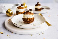 three small desserts on plates with gold spoons